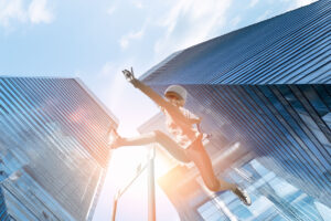 female hurdling with skyscrapers in the background